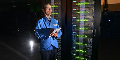 Photo of Luis Felipe Sopher de Popovics, Cray System Engineer, with the ARCHER supercomputer