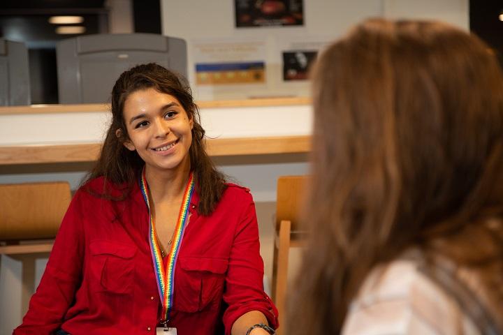 Student smiling at another student in conversation