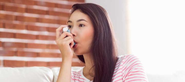 Young woman using an inhaler