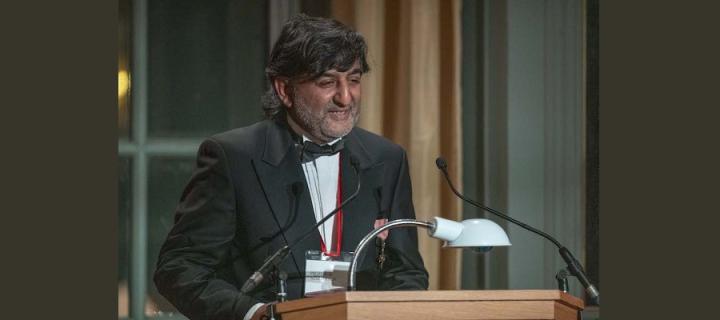 Professor Aziz Sheikh at lecturn at Chancellors Awards Gala Dinner 2021