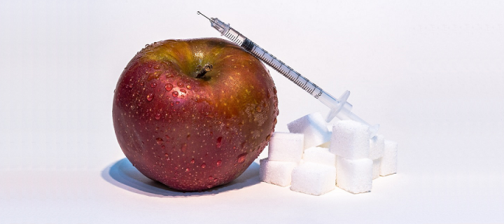 Apple, sugar cubes and syringe with insulin
