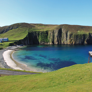 A sandy beach on Fair Isle, with a cliff face in the background