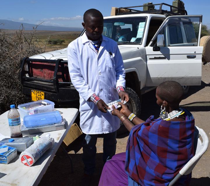 Doctor giving medicines to woman on a desk by the road.