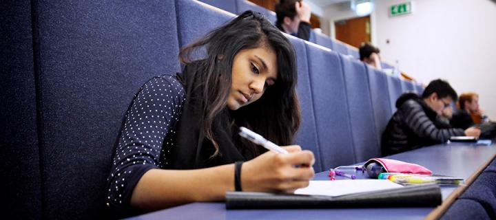 Undergraduate student taking notes during a lecture