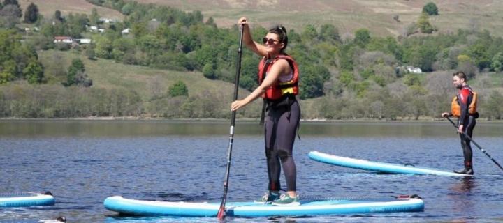 Girl paddling boarding on Loch Tay