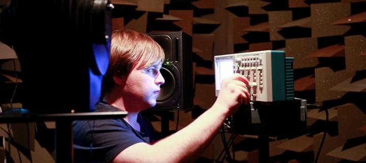 Student wearing headphones in an audio studio