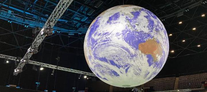 Large globe hanging from the ceiling at COP26