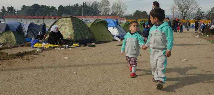 two small children refugees walking through camp