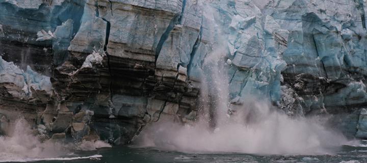 Melting ice from a glacier breaks off and crashes into the ocean due to climate warming