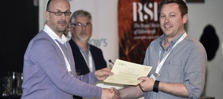 Douglas Gibson receiving a prize certificate from conference organisers