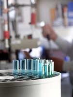 Test-tubes in foreground as researcher works in lab