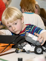 A child builds lego robots at Discover Science's 'Robofun'.