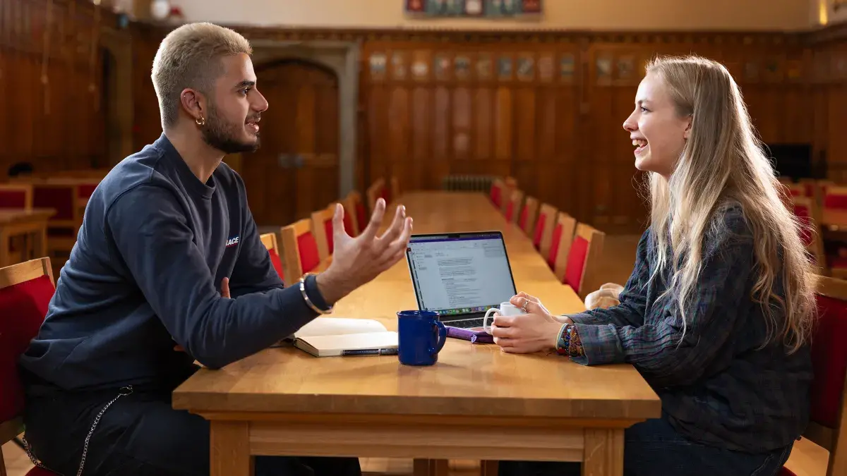 Two students chatting and working in Rainy Hall