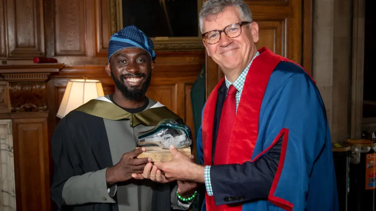 Hammed Kayode Alabi receives the Being Edinburgh Award from Chris Cox, Vice-Principal of Advancement and Philanthropy 