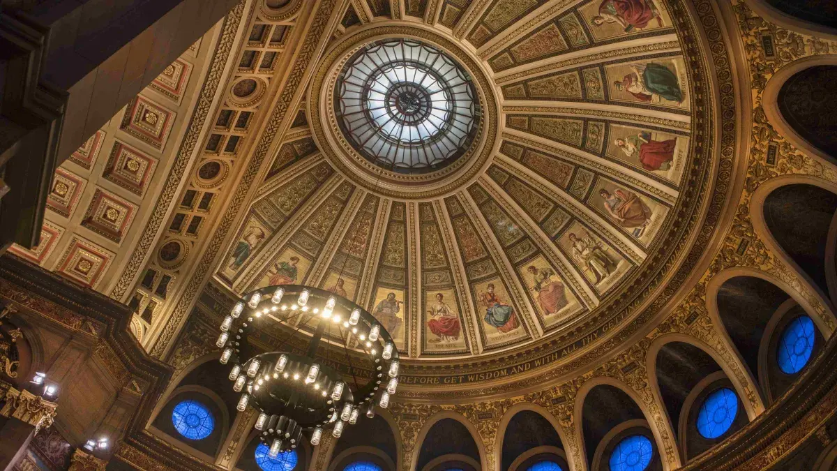 An upwards looking interior view of the intricate and colourful ceiling of the McEwan Hall