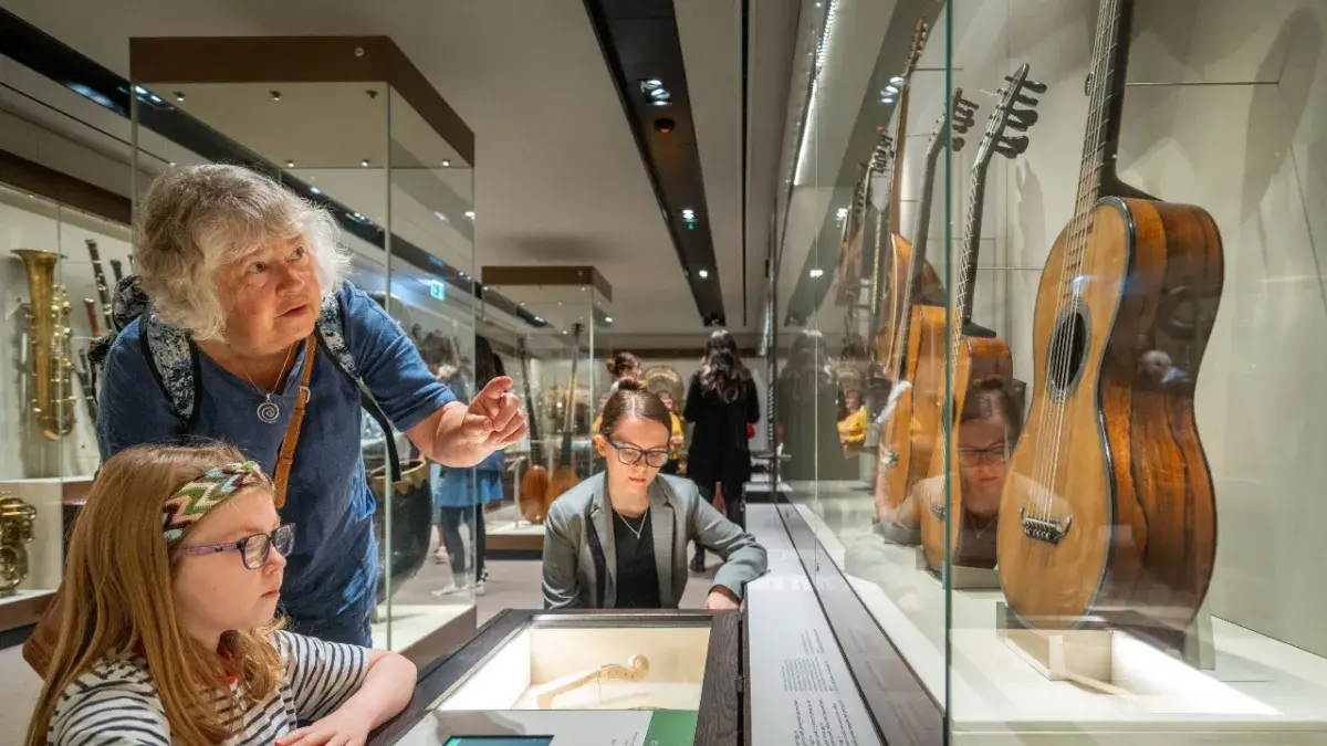 Two visitors examine an antique guitar at the ancient instrument museum at St Cecilia's Hall