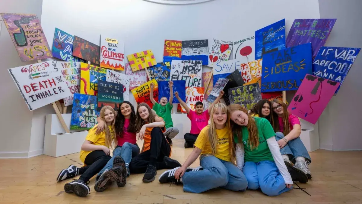 A group of young people from the Children's Parliament post with their artwork in the Talbot Rice Gallery.