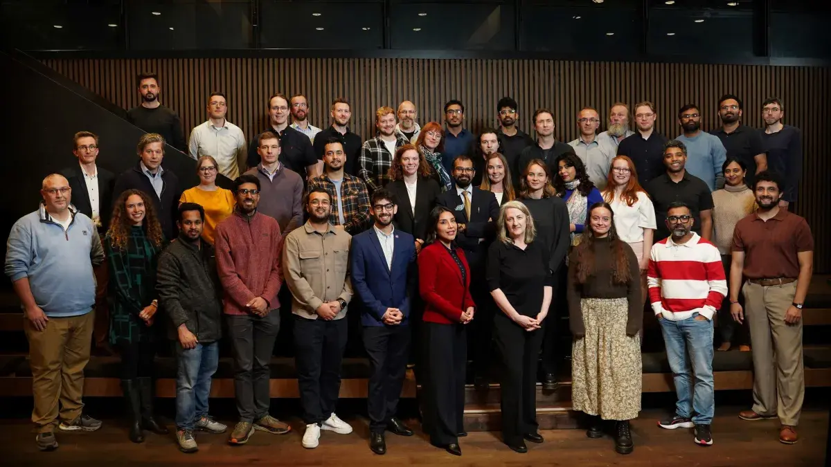 36 cohort members standing and looking to camera 