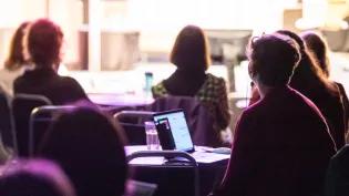 A group of people take part in a tech business lecture.