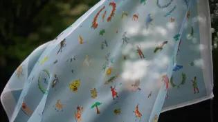 A textile flag featuring emblems from 60 countries blows in the wind. 