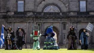 Six student pose in costumes on the Old College Quad lawn during a photocall for the Performance Costume Show 2025