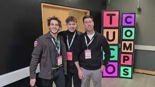 Three men pose for a photograph together at the TUCO 2025 competition.