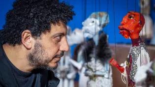 Wael Shawky poses with his hand-crafted murano glass marionettes, on display at the Talbot Rice Gallery.