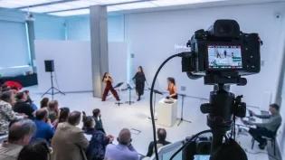 An audience takes part in an event in the white box interior of the InSpace gallery.