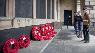 Members of the British Armed Forces pay respect at the War Memorial in the Old College Quadrangle, Edinburgh