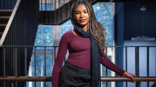 Hephzibah Adegoke stood by a staircase in Edinburgh Futures Institute