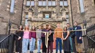 A group featuring students and staff from the University open Teviot with a ribbon-cutting moment.
