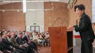 Dr Deng Yaping addresses the audience from a lectern in the University's South Hall