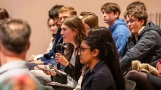 image of a school pupil with a microphone, asking councillors from across Edinburgh a question at a hustings event