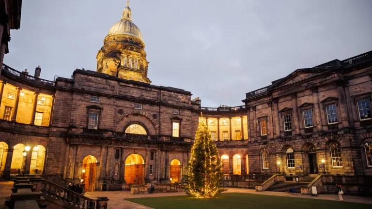 The buildings of Old College at the University of Edinburgh illuminated with a Christmas tree