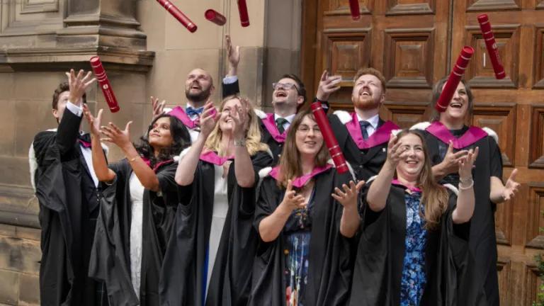 Graduates from the HCP-Med programme at the University of Edinburgh throw their degree certificate tubes into the air in front of McEwan Hall, Edinburgh