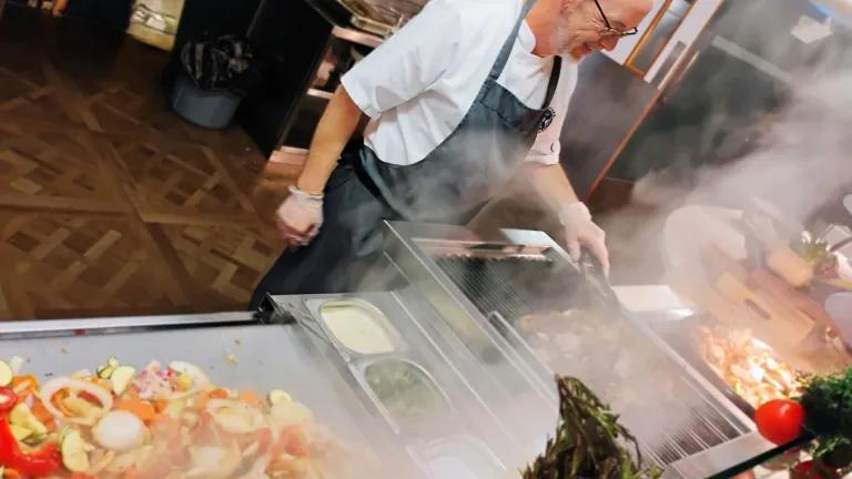 A chef prepares healthy dishes in University accommodation catering. 