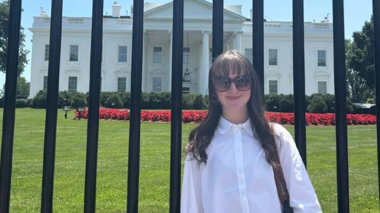 Annalie standing in white blouse in front of USA White House gates