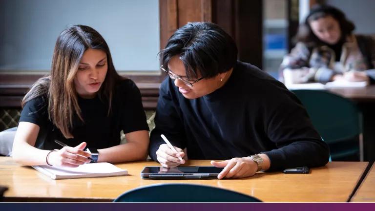 Two students making notes on ipad and notepad