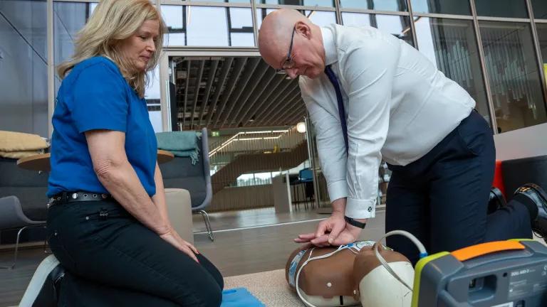 First Minister of Scotland John Swinney performs CPR on a model, assisted by Susan Gardner from Save a Life for Scotland