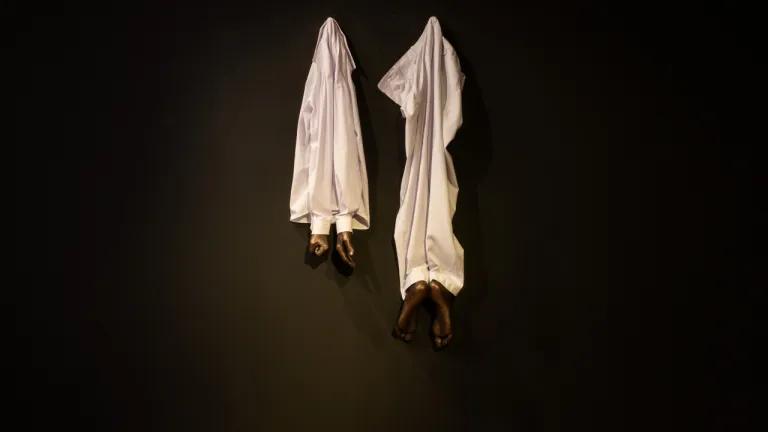 A sculpture made with bronze casts of human feet and sheets. 