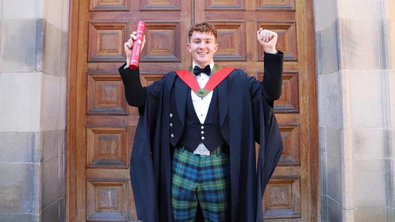 Archie Goodburn photographed outside McEwan Hall with his degree certificate
