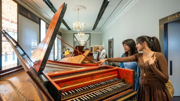 Two visitors explore the historic instrument collection at St Cecilia's Hall.