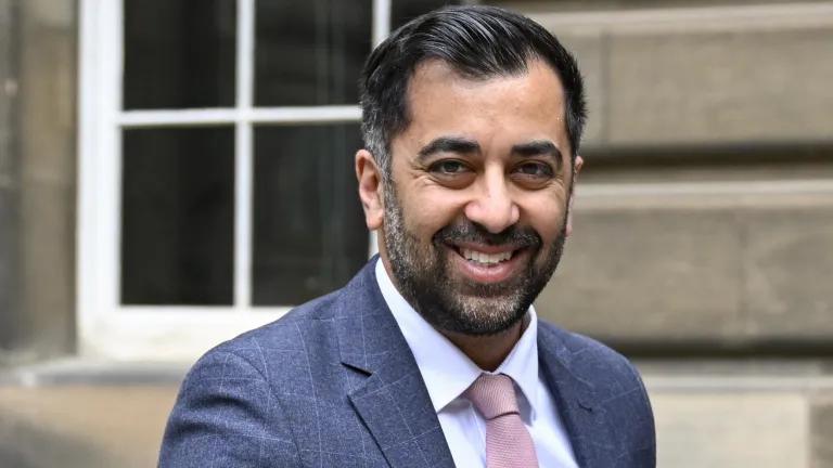 Head and shoulders photograph of Humza Housaf, stood in front of the Old Medical School, Edinburgh