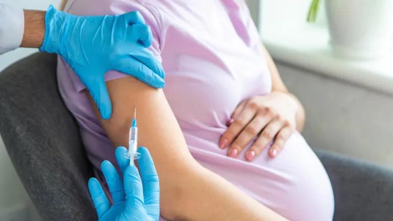 Close up of pregnant woman receiving vaccination