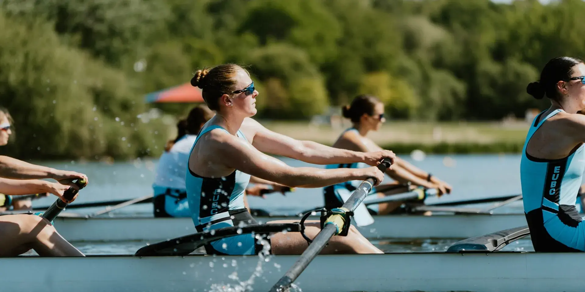 Women rowing with one female at the focus and others in background