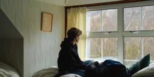 Teenager sitting on a bed