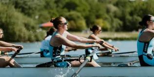 Women rowing with one female at the focus and others in background