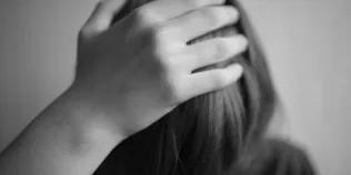 Black and white image of child with head in hands