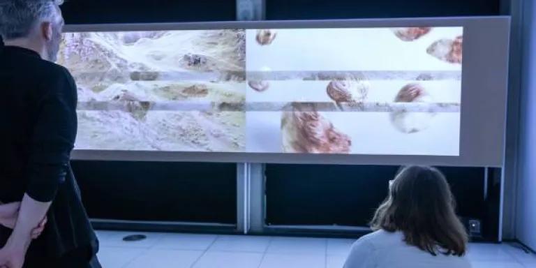 Two people lookng at a video screen of the Scottish landscape
