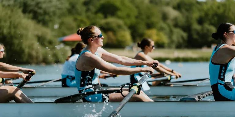 Women rowing with one female at the focus and others in background